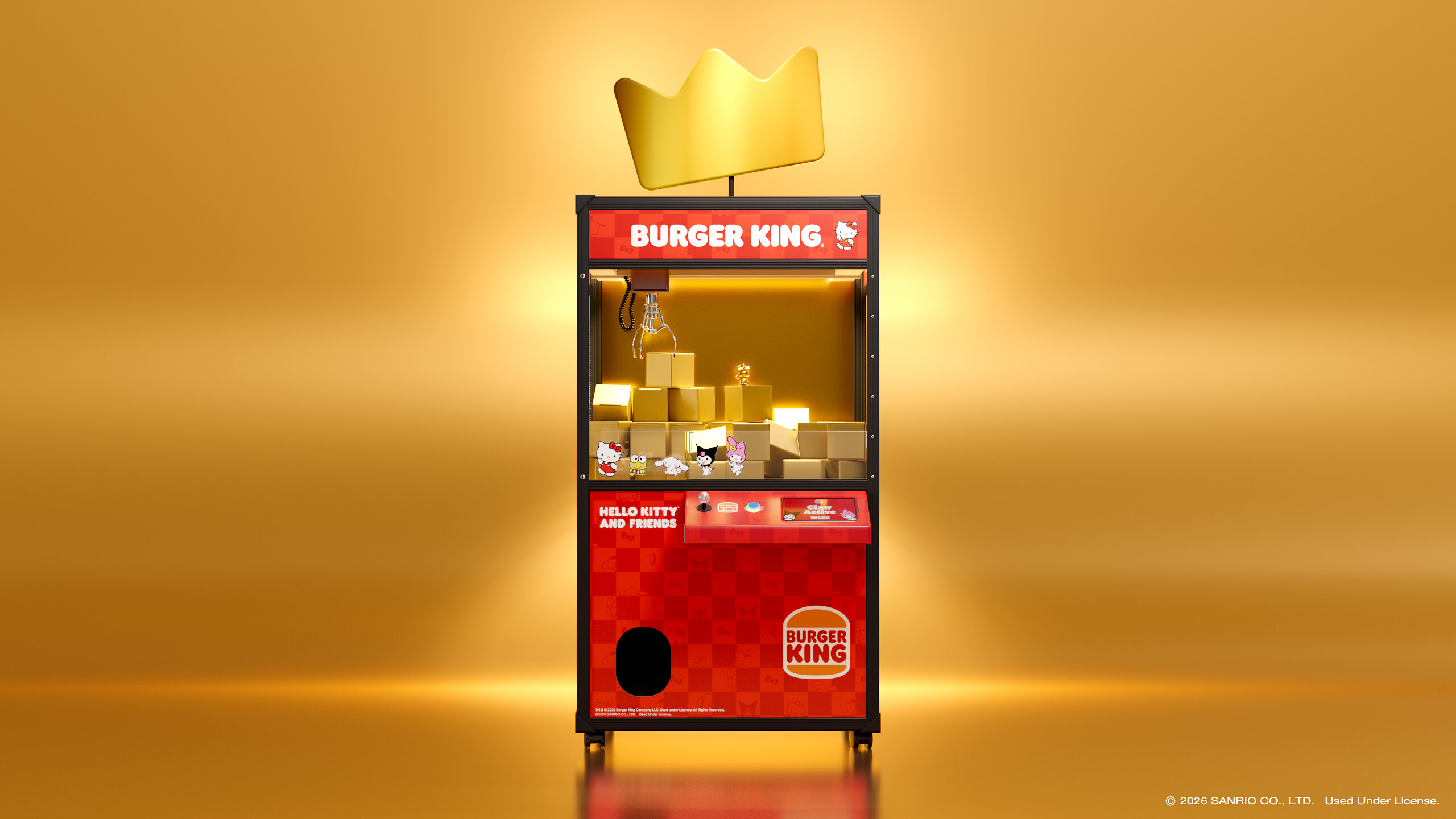 Press photo: a red Burger King claw machine topped with a gold crown, its glass case stacked with gold boxes, set against a glowing gold backdrop.
